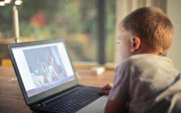 boy playing video games on laptop computer